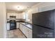 White kitchen cabinets, dark countertops, and a black refrigerator at 2331 Celia Ave, Charlotte, NC 28216