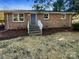 Brick ranch house with gray door, steps, and landscaping at 333 S High St, Waxhaw, NC 28173