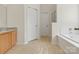 Bathroom features a tub, neutral-tile floors, a wood vanity, and a linen closet at 3865 Parkers Ferry Rd, Fort Mill, SC 29715