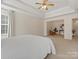 Spacious bedroom with trey ceilings, a ceiling fan, and neutral carpeting leading to a seating area at 3865 Parkers Ferry Rd, Fort Mill, SC 29715