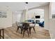 Bright dining area features modern lighting fixture and wood floors; open to the cozy living room with fireplace at 3865 Parkers Ferry Rd, Fort Mill, SC 29715