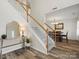 Foyer featuring a staircase with wood railing, decorative mirror, table with lamp, and access to the dining room at 3865 Parkers Ferry Rd, Fort Mill, SC 29715