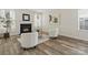 Cozy living room featuring a warm fireplace, neutral walls, wood floors, and soft, inviting armchairs at 3865 Parkers Ferry Rd, Fort Mill, SC 29715