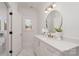 Modern bathroom with a round mirror and white cabinets at 3935 Black Sycamore Dr, Charlotte, NC 28226