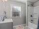 Updated bathroom with gray vanity, white tub, and tiled floor at 4532 Oakwood Cir, Gastonia, NC 28056