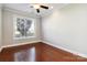 Bright bedroom with hardwood floors, large window, and ceiling fan at 4855 Star Hill Ln, Charlotte, NC 28214