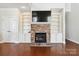 Stone fireplace with built-in shelving and large TV above at 4855 Star Hill Ln, Charlotte, NC 28214