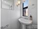 Stylish bathroom featuring a pedestal sink, modern fixtures, and a window for natural light at 544 New Bern Station Ct, Charlotte, NC 28209