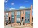 Brick townhomes with stoops, large windows, and painted window frames under a partly cloudy, blue sky at 544 New Bern Station Ct, Charlotte, NC 28209