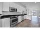 Modern kitchen with stainless steel appliances, black countertops, and white cabinets in an open layout at 544 New Bern Station Ct, Charlotte, NC 28209