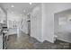 Hallway to kitchen area featuring modern appliances, tile flooring, white cabinets, and an adjacent half bathroom at 544 New Bern Station Ct, Charlotte, NC 28209