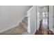 Carpeted staircase with white railings leading to a hardwood-floored hallway with natural light at 544 New Bern Station Ct, Charlotte, NC 28209