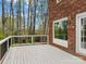 Outdoor deck with white railing, red brick home, and scenic tree-lined backyard at 5972 Rathlin Nw Ct, Concord, NC 28027