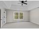 Spacious bedroom with plush carpet, a tray ceiling with fan and a large window that provides ample natural light at 5972 Rathlin Nw Ct, Concord, NC 28027