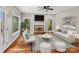 Virtually staged living room featuring hardwood floors, a fireplace, a ceiling fan, and a cozy seating area at 5972 Rathlin Nw Ct, Concord, NC 28027