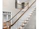 Elegant staircase with wooden railing and carpet at 5972 Rathlin Nw Ct, Concord, NC 28027