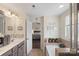 A charming bathroom showcasing double sinks, a bathtub with tile surround, and an open doorway to the primary bedroom at 6007 Cadence Ln, Indian Land, SC 29707