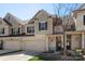 Inviting townhome with a two-car garage, charming entry bench, and budding tree, offering a warm welcome at 6007 Cadence Ln, Indian Land, SC 29707