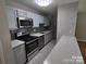 Modern kitchen with stainless steel appliances and gray cabinets at 6106 Meadow Rose Ln, Charlotte, NC 28215