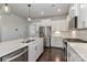 Open kitchen with stainless appliances, white cabinets, island, and hardwood floors at 6503 Georgia Oak Rd, Charlotte, NC 28269