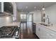 Open-concept kitchen featuring modern appliances, white cabinets, island, and hardwood floors overlooking the living area at 6503 Georgia Oak Rd, Charlotte, NC 28269