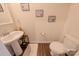 Updated powder room with pedestal sink, decorative accents, and wood-look flooring at 6525 Gopher Rd, Indian Land, SC 29707