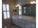 Double vanity bathroom with a large mirror and shower at 9018 Kestral Ridge Dr, Charlotte, NC 28269