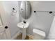 Clean powder room with pedestal sink, toilet, and glass shelving at 9140 Carneros Creek Rd, Charlotte, NC 28214