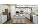 Modern kitchen with white cabinets and island at 1002 Merganser Way, Indian Trail, NC 28079