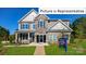 Two-story home with stone and gray siding, landscaped yard at 1023 Merganser Way, Indian Trail, NC 28079