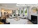 Open living room showcasing fireplace, kitchen view, and ample natural light at 1023 Merganser Way, Indian Trail, NC 28079