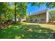 Expansive backyard showcases a well-kept lawn, trees, and a patio area ideal for outdoor living and entertaining at 11006 Knight Castle Dr, Charlotte, NC 28277