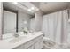 Bright bathroom featuring a double sink vanity, large mirror, and a shower with white shower curtain at 11006 Knight Castle Dr, Charlotte, NC 28277