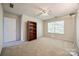 Empty bedroom features a ceiling fan, neutral carpet, and a bookshelf at 11006 Knight Castle Dr, Charlotte, NC 28277