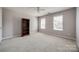 Spacious bedroom with neutral carpet, bookshelf, and two large windows at 11006 Knight Castle Dr, Charlotte, NC 28277