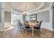 Formal dining room showcasing a chandelier, beautiful ceiling detail, and a large window for ample natural light at 11006 Knight Castle Dr, Charlotte, NC 28277