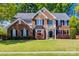 Beautiful brick two-story home featuring manicured lawn, well-maintained landscaping, and elegant architectural details at 11006 Knight Castle Dr, Charlotte, NC 28277