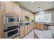 Galley kitchen with wood cabinets, granite countertops, tile floors, and stainless appliances at 11006 Knight Castle Dr, Charlotte, NC 28277