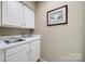 Practical laundry area with a sink, counter space, and white cabinetry for convenient storage solutions at 11006 Knight Castle Dr, Charlotte, NC 28277