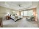 Spacious main bedroom featuring a tray ceiling, large windows, and comfortable seating area at 11006 Knight Castle Dr, Charlotte, NC 28277