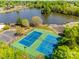 Aerial view showcases tennis courts near a picturesque lake surrounded by trees, offering a serene recreational space at 11006 Knight Castle Dr, Charlotte, NC 28277