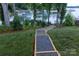 Backyard stone staircase leading to the lake featuring beautiful landscaping and lighting at 113 Angler Pl, Mooresville, NC 28117