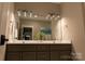Bright bathroom featuring a large mirror with modern lighting, double sinks, and neutral countertops at 113 Angler Pl, Mooresville, NC 28117