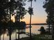 Beautiful sunset view of the lake, framed by tall trees and docks for boating at 113 Angler Pl, Mooresville, NC 28117