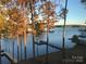Picturesque lake view framed by beautiful autumn trees and docks at 113 Angler Pl, Mooresville, NC 28117