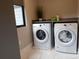 Well-equipped laundry room with modern washer and dryer units, a sleek countertop, and a bright window at 113 Angler Pl, Mooresville, NC 28117