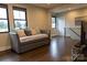 Stylish living room with a cozy daybed, hardwood floors, and ample natural light from multiple windows at 113 Angler Pl, Mooresville, NC 28117