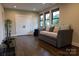 Inviting living room featuring a comfortable daybed, hardwood floors, and three windows offering natural light and views at 113 Angler Pl, Mooresville, NC 28117