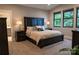 Relaxing main bedroom with a dark wood bed frame, plush carpet, and natural light from black-trimmed windows at 113 Angler Pl, Mooresville, NC 28117