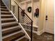 Elegant staircase with dark wood steps and modern black metal railing, leading to a convenient mudroom area at 113 Angler Pl, Mooresville, NC 28117